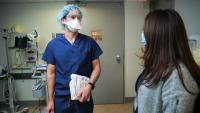 Two clinicians speak to each other in an exam room